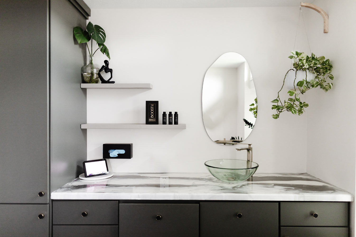 Photo of a treatment room inside Simply Steele Skin.  Steel black cabinets with a white and black marble counter tops and a glass bowl sink.