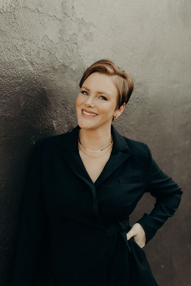 Portrait of Steele against a black and grey concrete wall.